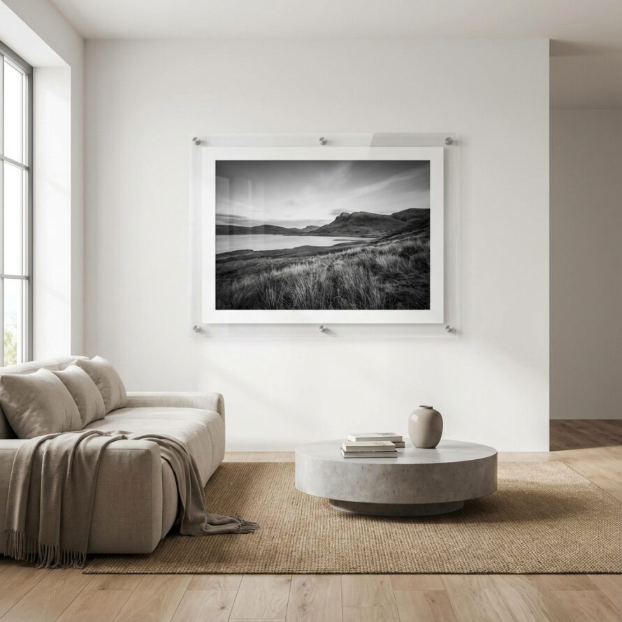 Transparante plexiglas fotolijst met zwart-wit berglandschap, gemonteerd boven een houten dressoir in een rustig interieur.