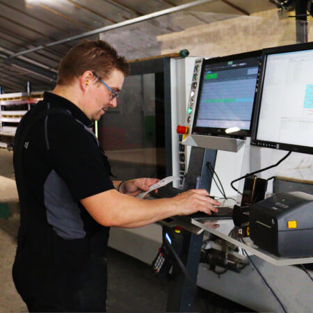 Medewerker achter CNC-machine platen frezen