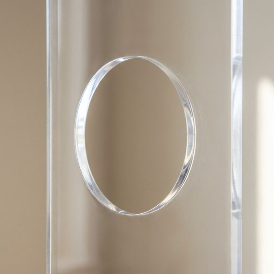 Detailopname van de afvoerslang van een mobiele airco die door een plexiglas raamafdichting naar buiten wordt geleid.