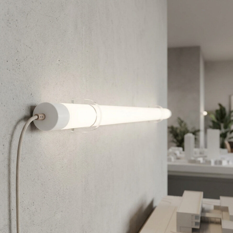Witte plexiglas LED-tube met zichtbare kabelaansluiting en wandmontage in modern interieur.
