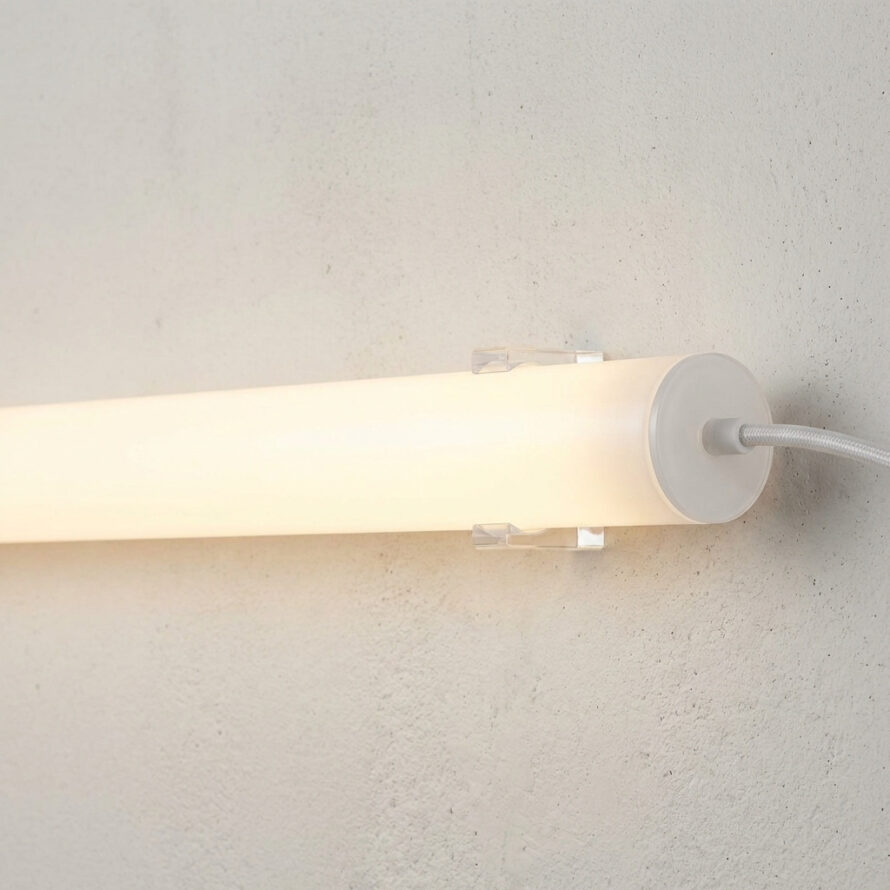 Opaal plexiglas LED-buis met warm wit licht, gemonteerd aan een muur met ronde wandbevestiging.