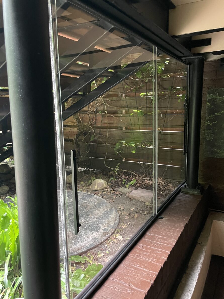 Buitenzijde van een gebogen plexiglas serre met volledig glazen/plexiglas wand.