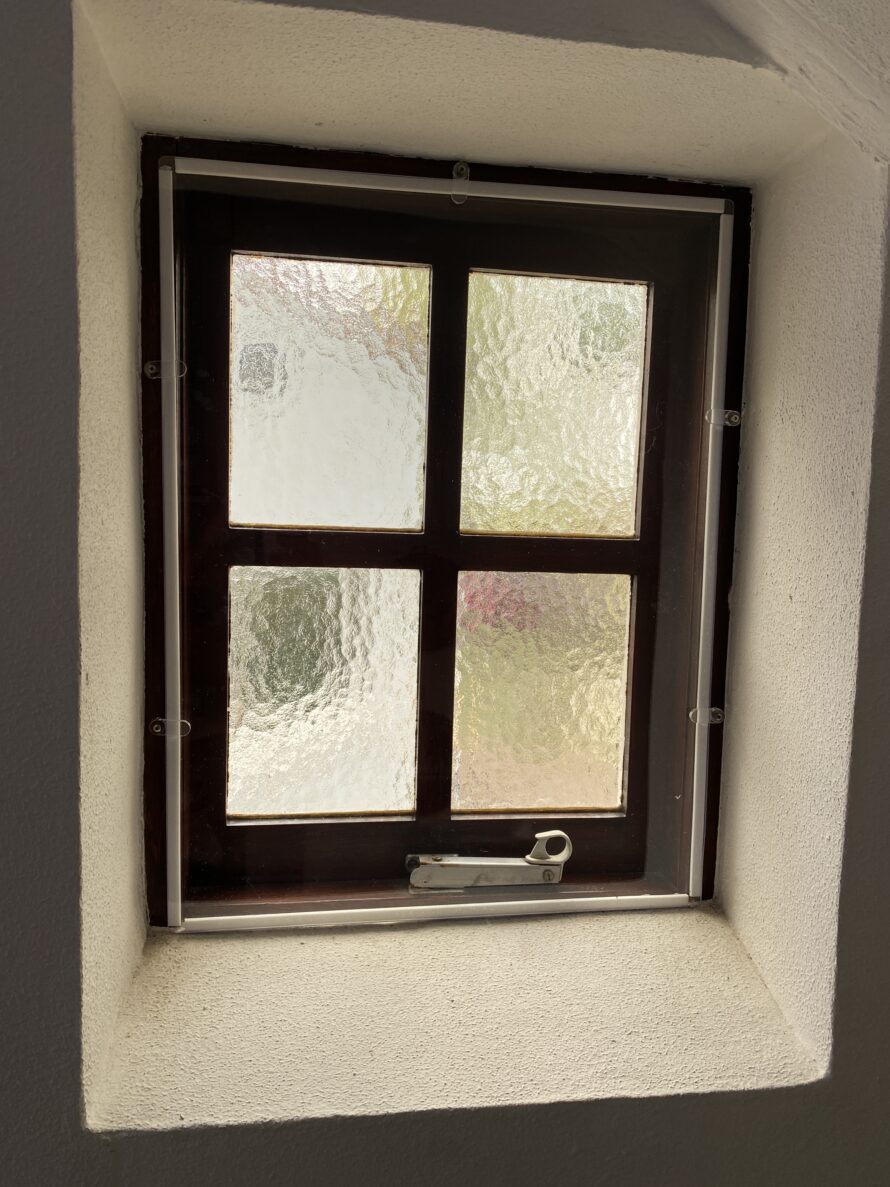 Klein houten raam met twee ruiten en matglas.